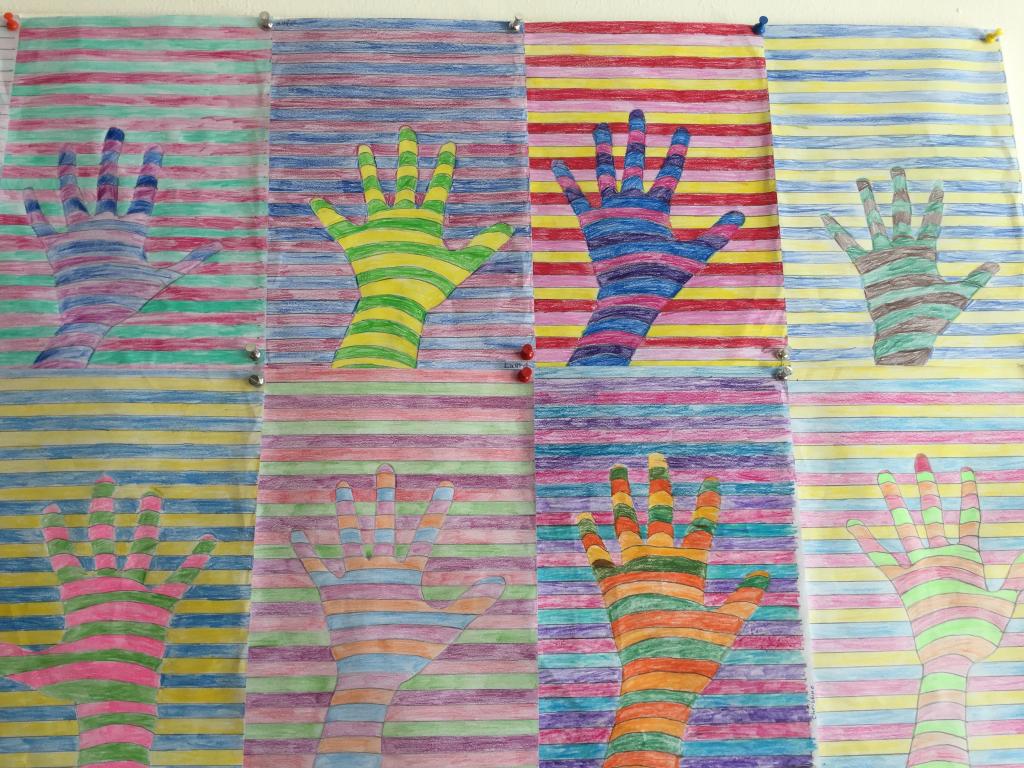 Foto mit bunten gemalten Händen vor einem gestreiften Hintergrund