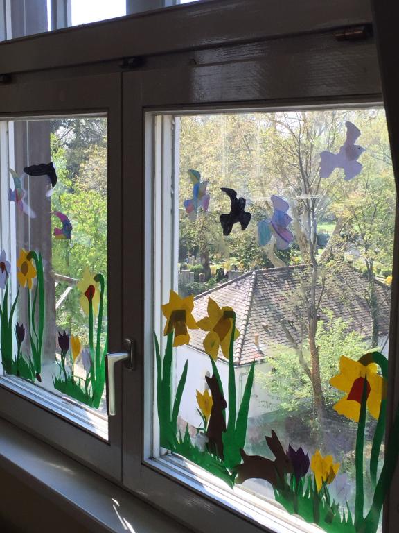 Foto eines Fensters mit gebastelten Frühlingsblumen